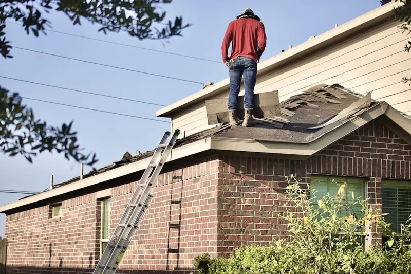 Professional roofer working on a residential roof in Milford